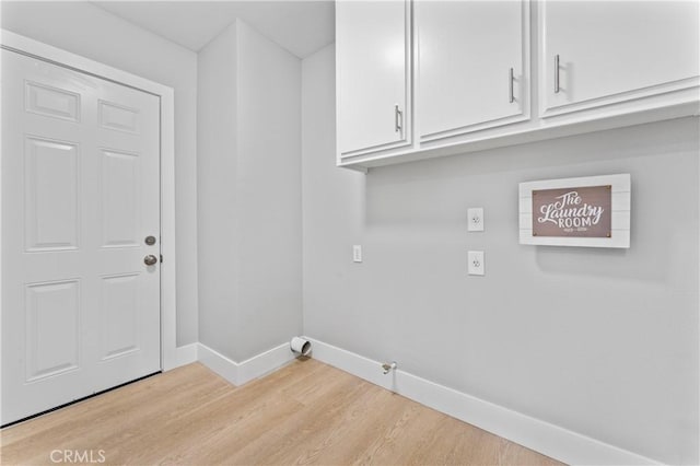 laundry area featuring cabinets and light hardwood / wood-style flooring