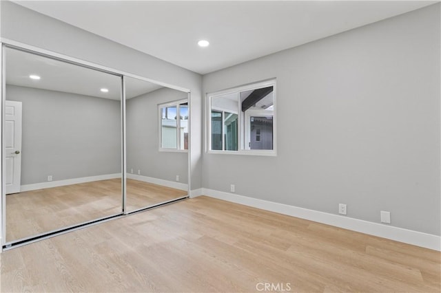 unfurnished bedroom with a closet and light hardwood / wood-style flooring