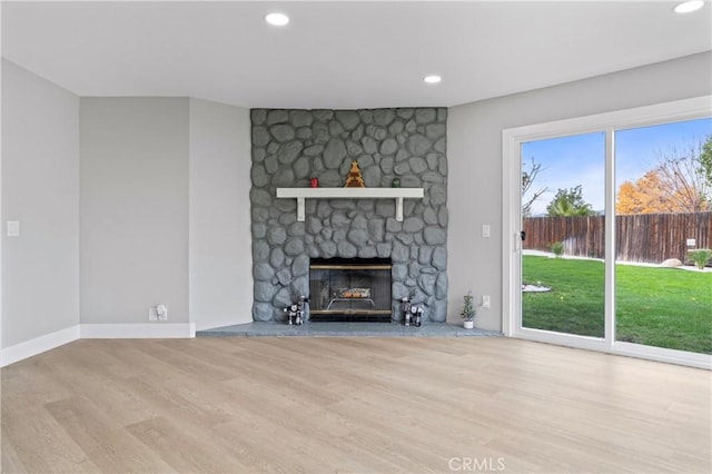 unfurnished living room with a fireplace and light wood-type flooring