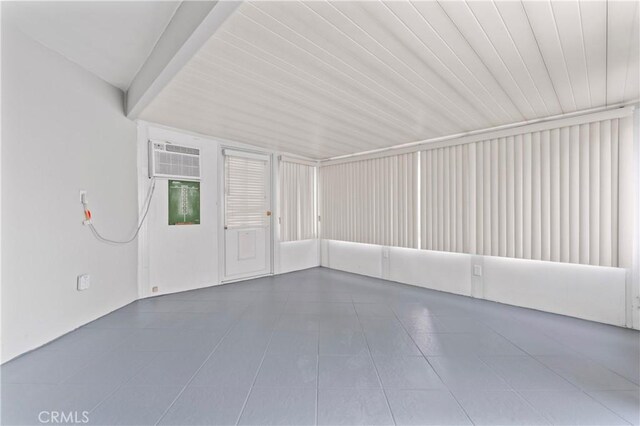 tiled empty room with an AC wall unit and wood ceiling