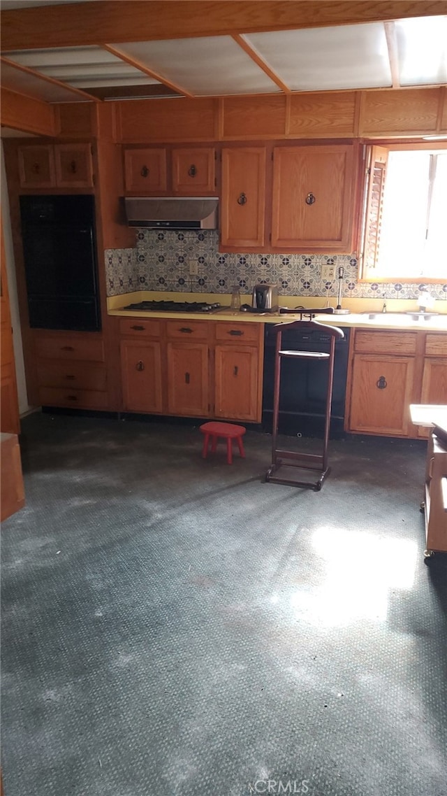 kitchen featuring decorative backsplash, sink, black oven, and white gas stovetop