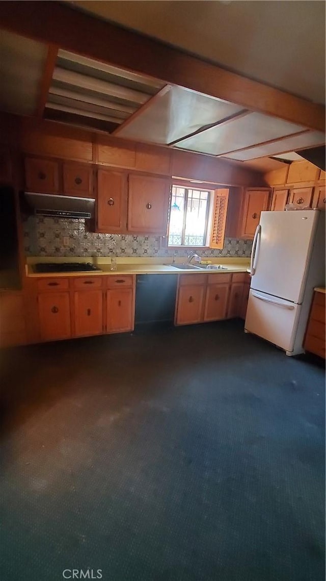 kitchen featuring sink, backsplash, cooktop, exhaust hood, and white fridge