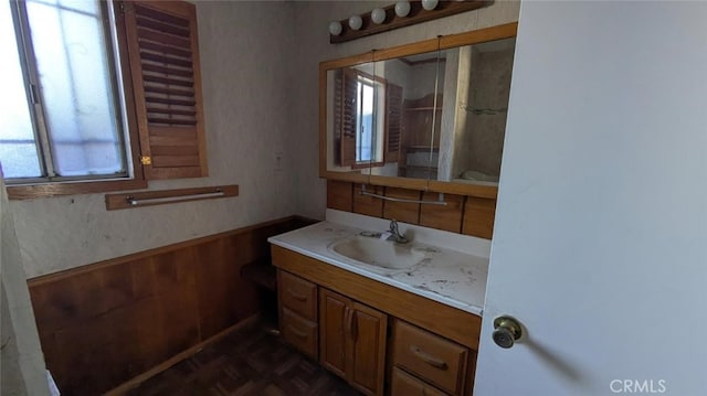 bathroom featuring vanity, parquet flooring, and wood walls