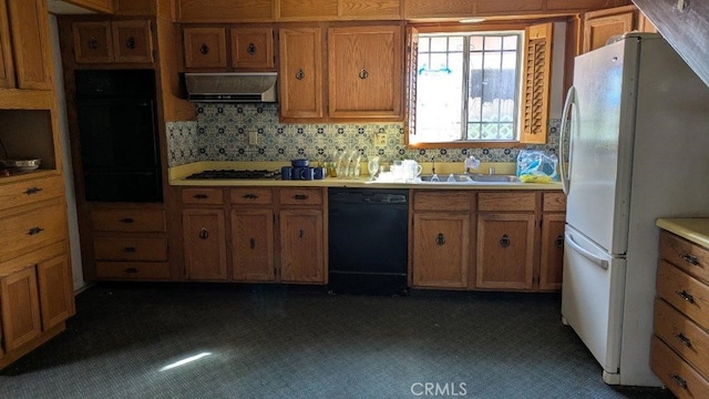 kitchen featuring sink, decorative backsplash, and black appliances