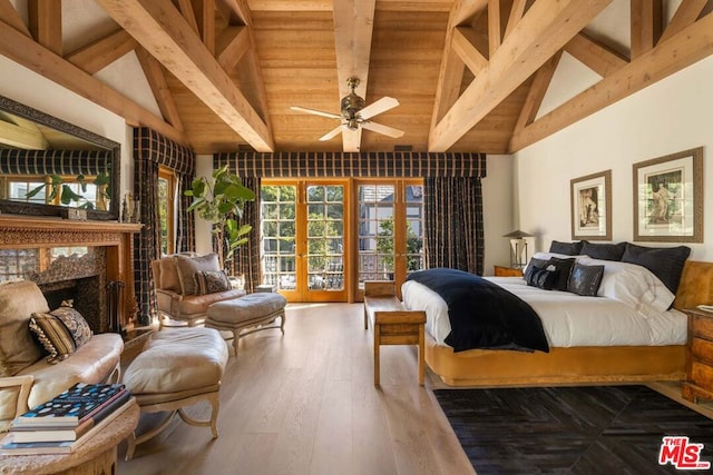 bedroom featuring beamed ceiling, access to exterior, a premium fireplace, dark wood-type flooring, and french doors