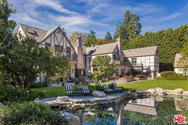 back of property featuring a yard and a balcony