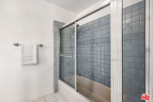 bathroom featuring tile patterned flooring and combined bath / shower with glass door