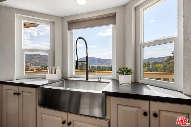 kitchen featuring a mountain view, white cabinetry, and sink