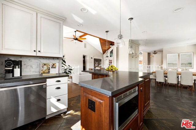 kitchen with decorative light fixtures, white cabinetry, appliances with stainless steel finishes, and vaulted ceiling