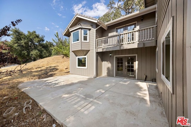 rear view of house featuring a patio area and a balcony