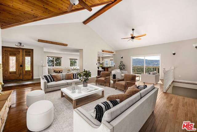 living room featuring hardwood / wood-style flooring, plenty of natural light, beam ceiling, and high vaulted ceiling