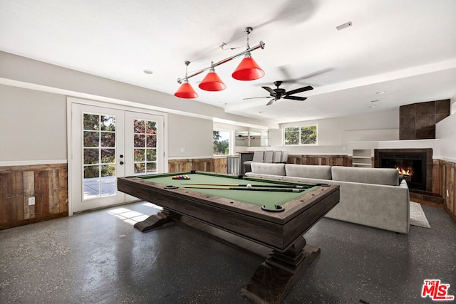 game room featuring a fireplace, french doors, wooden walls, and pool table