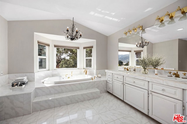 bathroom with vanity, tiled tub, lofted ceiling, and a wealth of natural light