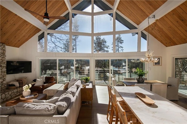 sunroom with lofted ceiling with beams, wooden ceiling, and ceiling fan with notable chandelier