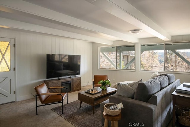 carpeted living room featuring beam ceiling