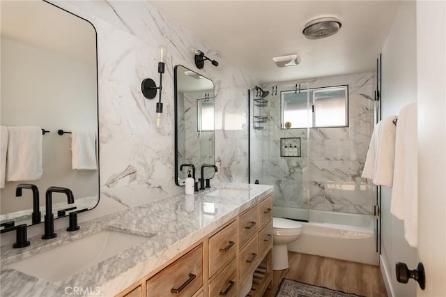 full bathroom with toilet, vanity, wood-type flooring, and combined bath / shower with glass door