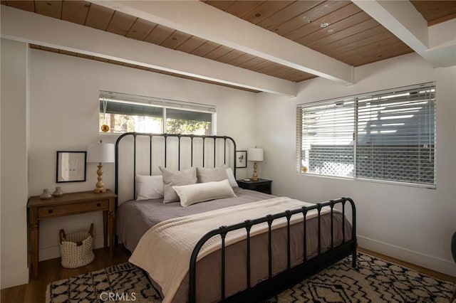 bedroom featuring hardwood / wood-style floors, beam ceiling, and wooden ceiling