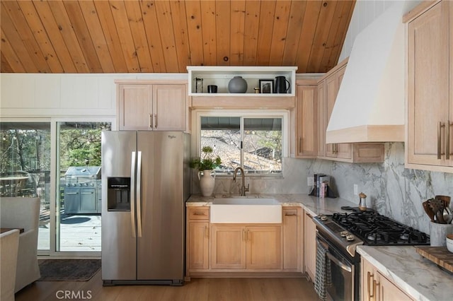 kitchen featuring sink, light brown cabinetry, premium range hood, and appliances with stainless steel finishes