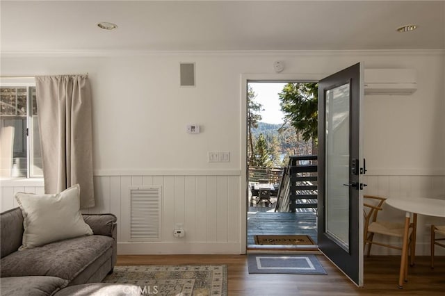 doorway to outside featuring crown molding, dark hardwood / wood-style flooring, and a wall mounted air conditioner