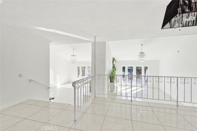 hallway featuring french doors, a healthy amount of sunlight, and light tile patterned flooring