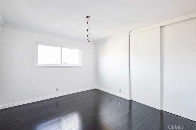 empty room featuring dark hardwood / wood-style flooring and ornamental molding