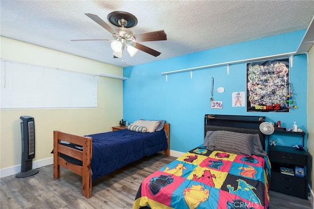 bedroom with ceiling fan, a textured ceiling, and hardwood / wood-style flooring