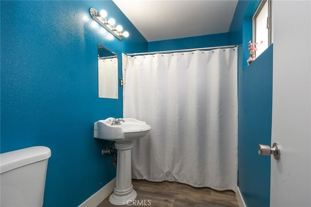 bathroom with wood-type flooring and toilet