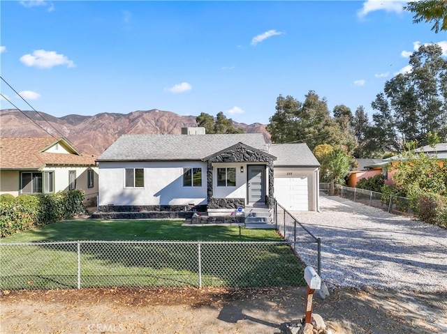 view of front facade featuring a front yard, a mountain view, and a garage