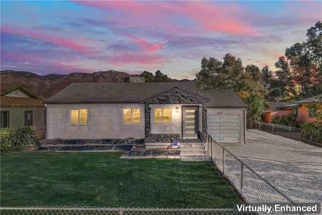 view of front facade featuring a mountain view, a garage, and a lawn