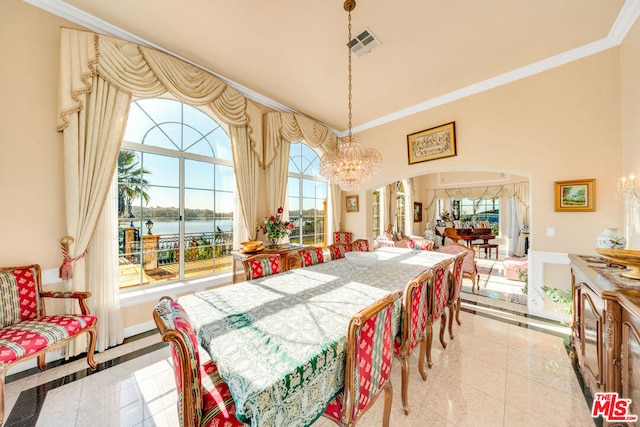 dining area with a water view, ornamental molding, a wealth of natural light, and an inviting chandelier