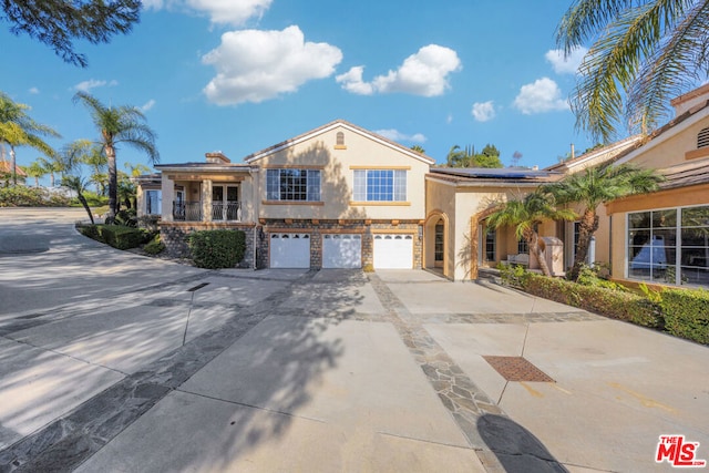 view of front of property featuring solar panels and a garage