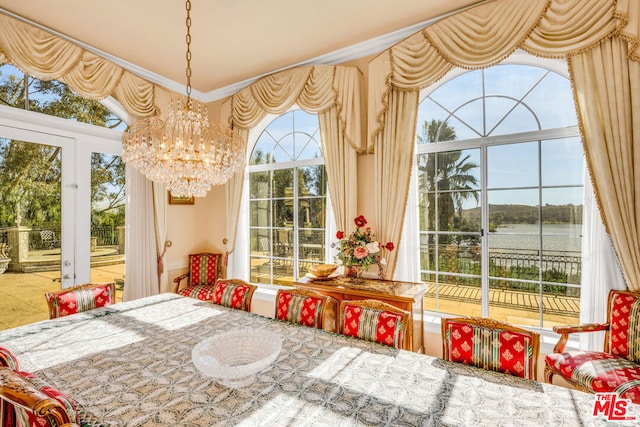 sunroom / solarium featuring a wealth of natural light, a water view, and a chandelier