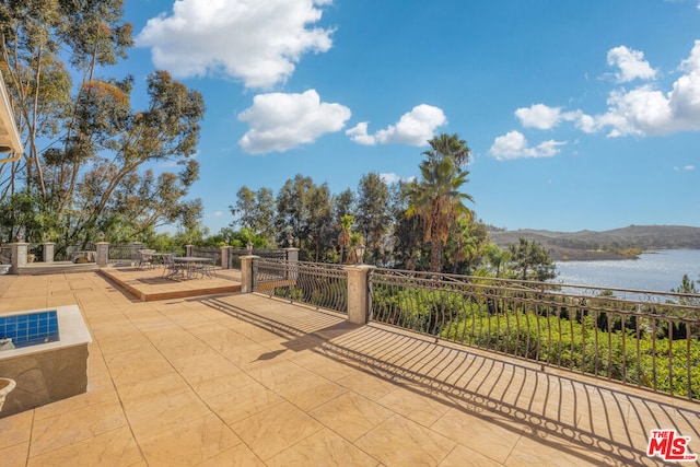 view of patio featuring a water and mountain view