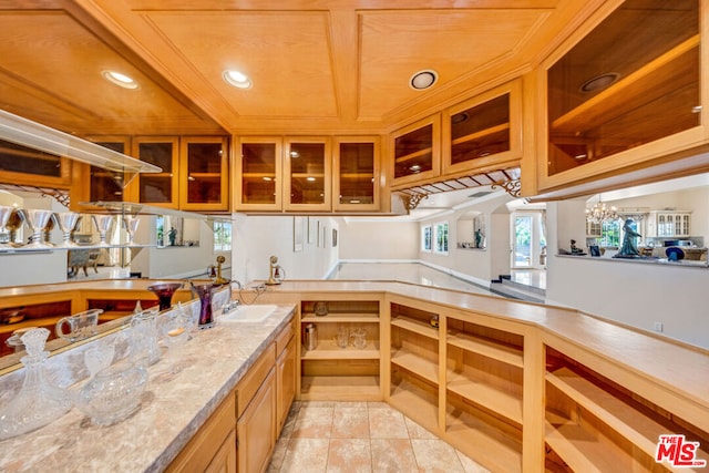 kitchen featuring wood ceiling, light stone countertops, sink, and light tile patterned floors