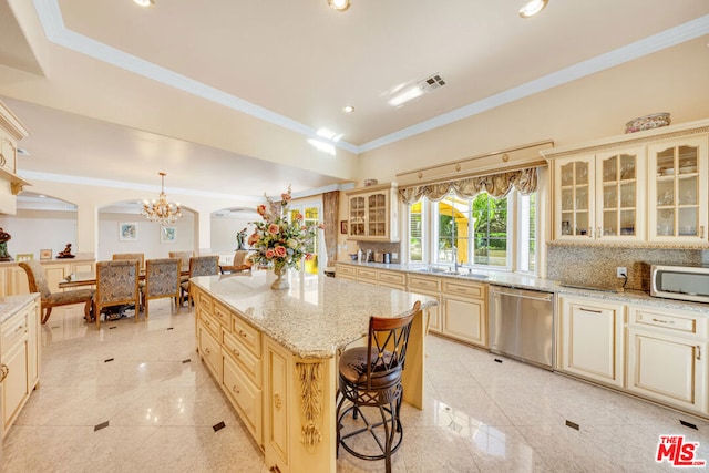 kitchen featuring dishwasher, a kitchen breakfast bar, decorative light fixtures, decorative backsplash, and a kitchen island