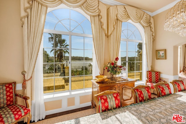 doorway with tile patterned floors, crown molding, plenty of natural light, and a notable chandelier