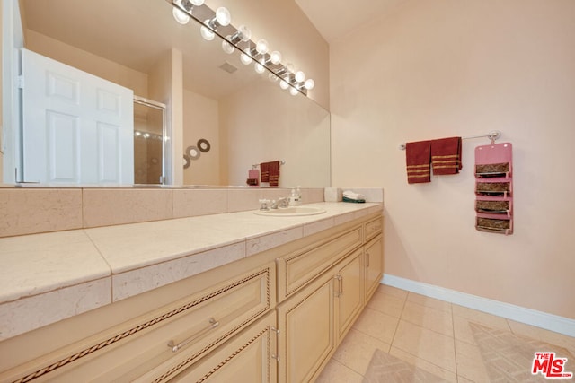 bathroom featuring tile patterned flooring, vanity, and an enclosed shower