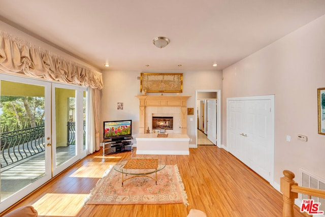 living room with hardwood / wood-style flooring, plenty of natural light, and french doors