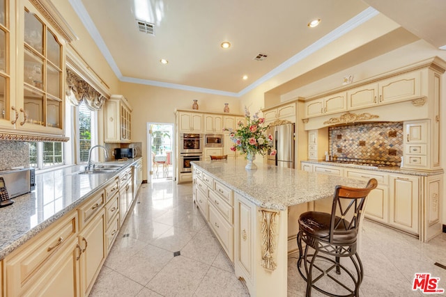 kitchen with a kitchen island, crown molding, sink, and tasteful backsplash