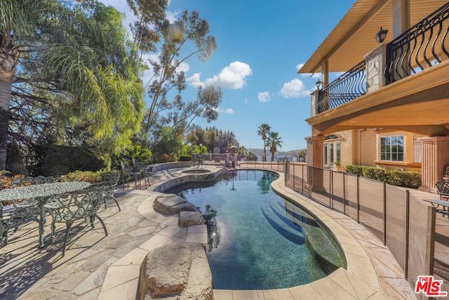 view of swimming pool featuring a patio area and an in ground hot tub