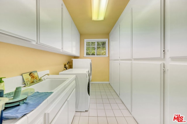 laundry area featuring cabinets, light tile patterned floors, and washing machine and clothes dryer