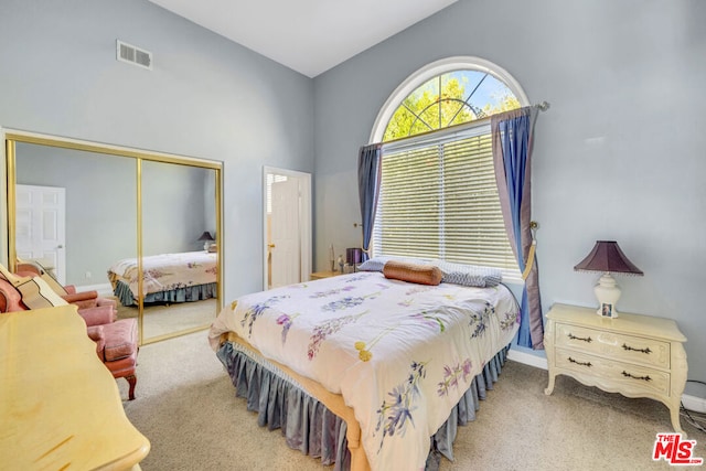 bedroom featuring carpet floors, a towering ceiling, and a closet