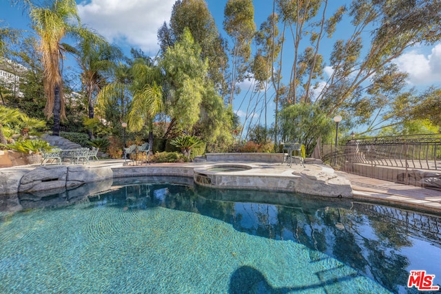 view of pool featuring an in ground hot tub