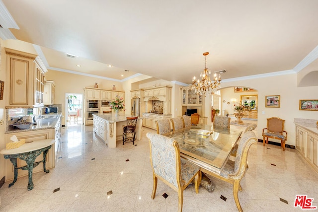 dining space with sink, a notable chandelier, and ornamental molding