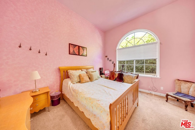 bedroom with light colored carpet and lofted ceiling