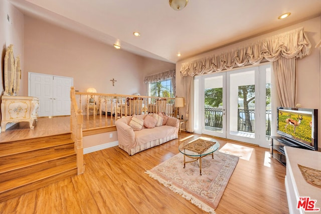 living room featuring hardwood / wood-style floors, lofted ceiling, and french doors