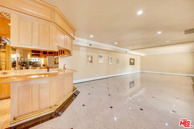 kitchen featuring backsplash, sink, crown molding, light brown cabinetry, and light tile patterned flooring