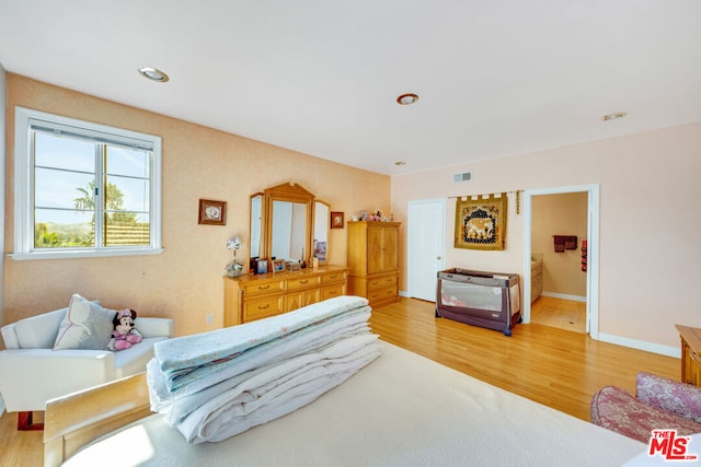 bedroom with light hardwood / wood-style floors and ensuite bath