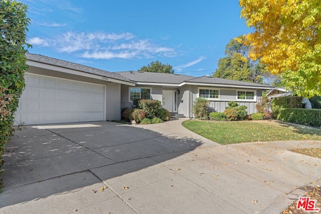 ranch-style home featuring a garage and a front lawn