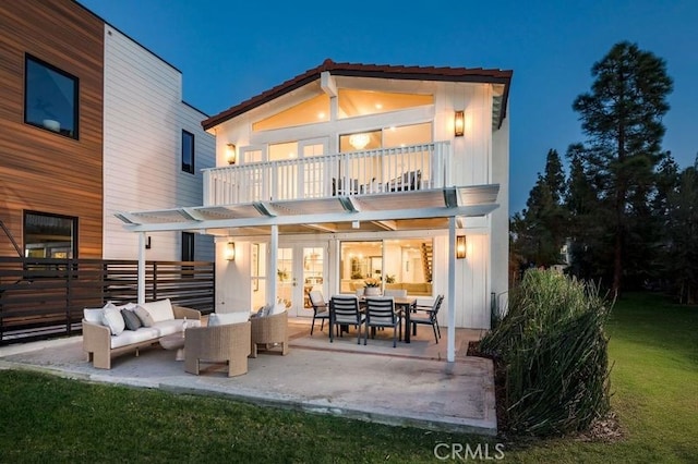 rear view of property with outdoor lounge area, a balcony, and a patio